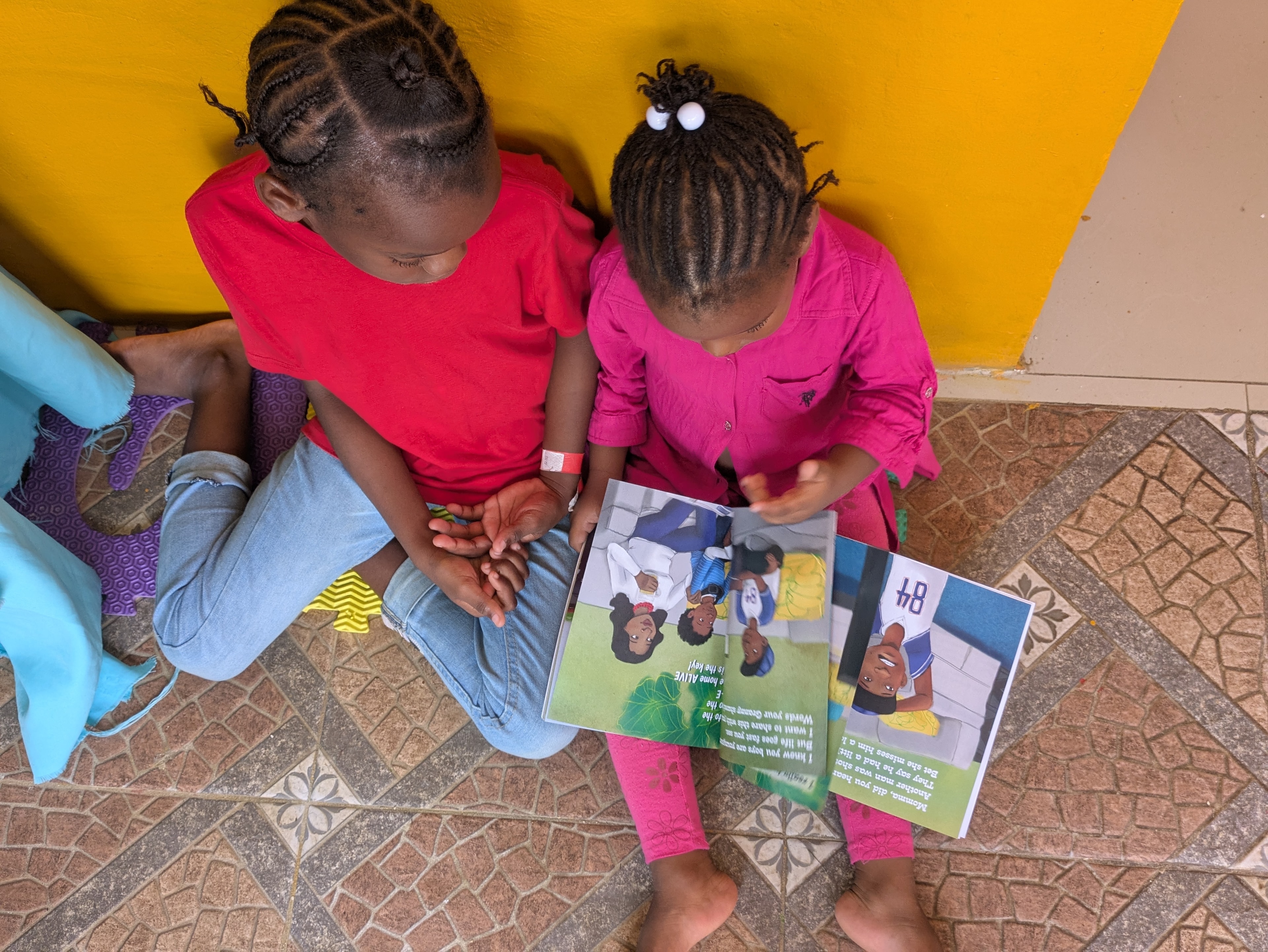 Two children reading a book together on the floor