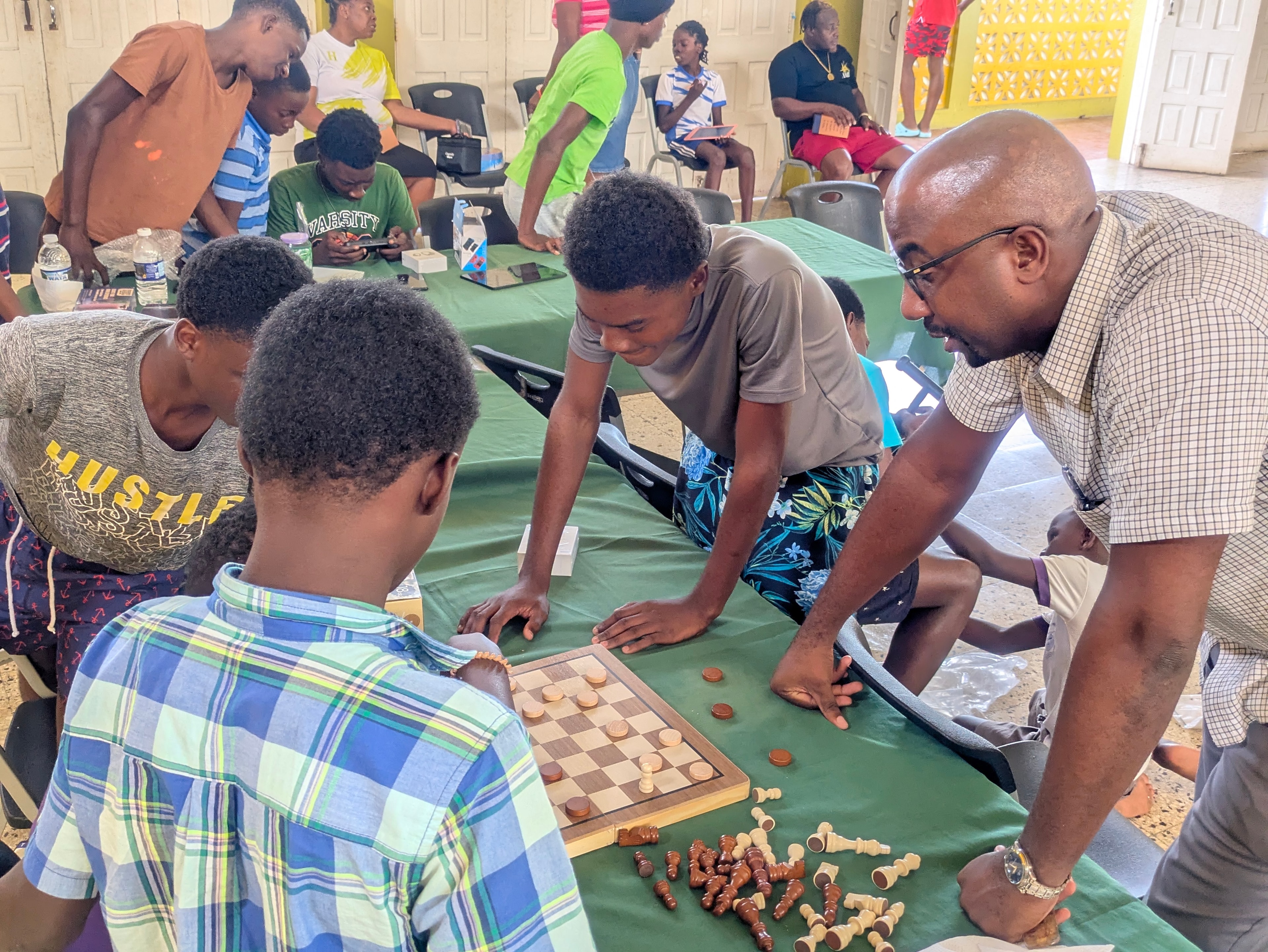 Youth and mentor playing chess and checkers at a community event