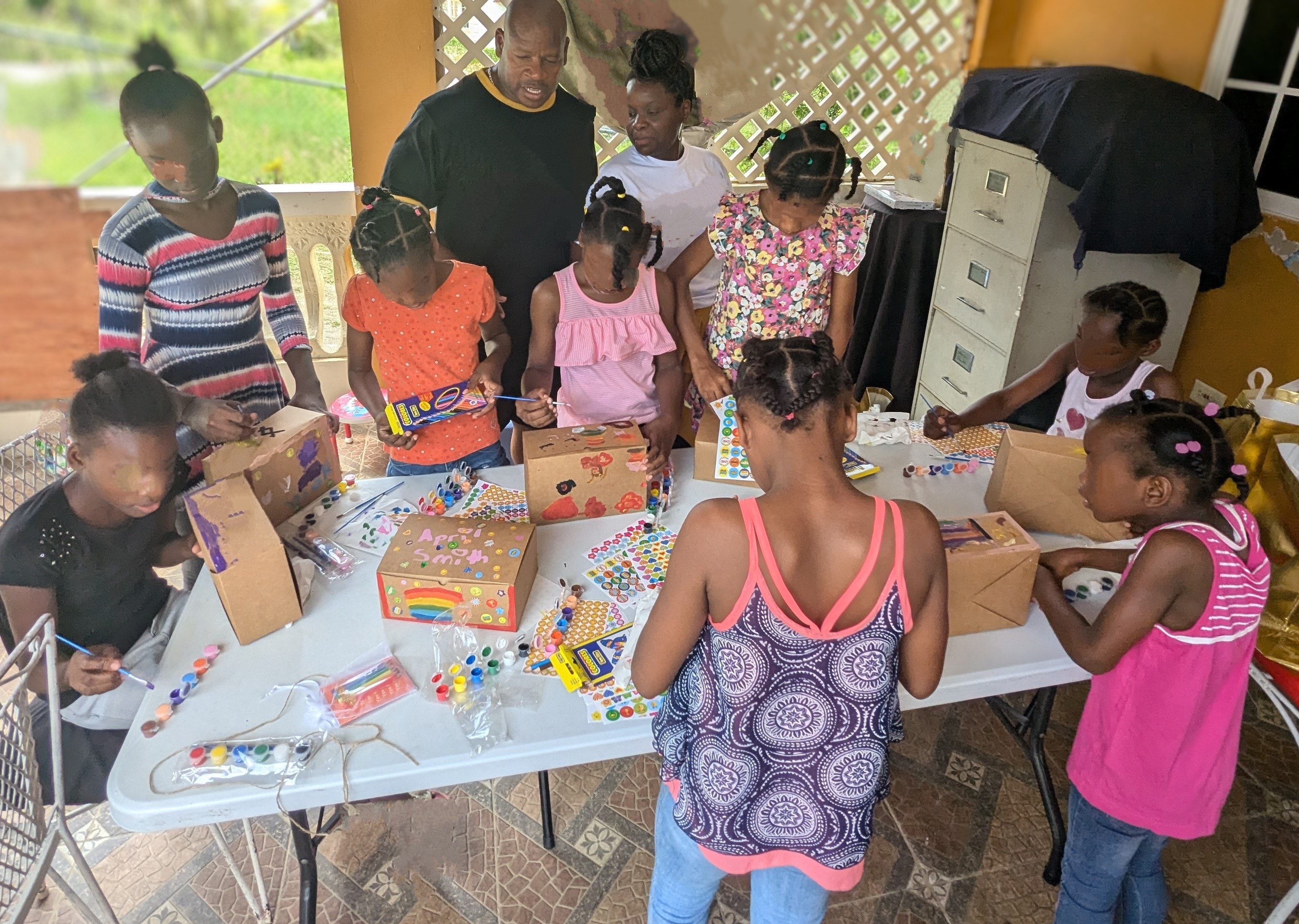 Children and adults doing arts and crafts at a community activity table